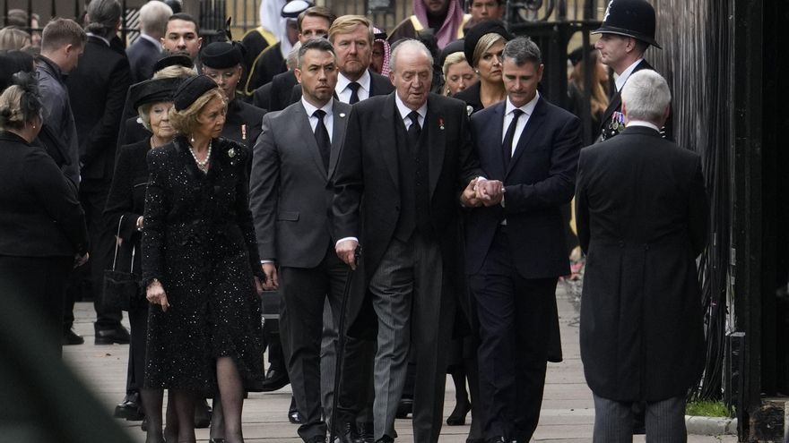 El rey emérito Juan Carlos I camina ayudado de un asistente junto a la reina Sofía a su llegada al funeral de Isabel II en Londres.