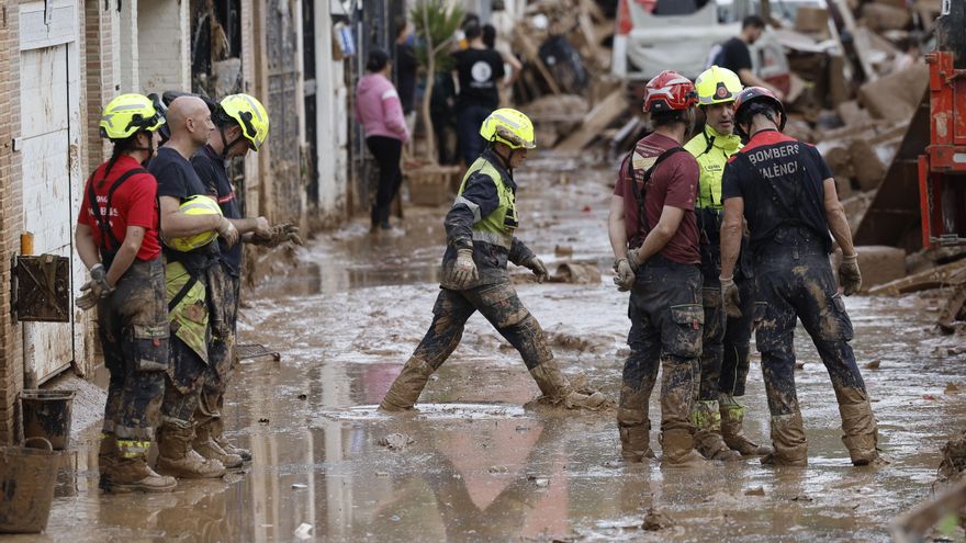 Efectivos del cuerpo de bomberos trabajan en la limpieza y retirada del lodo en Alfafar (Valencia), este viernes. EFE/ Kai Försterling