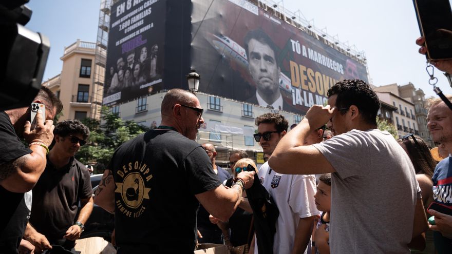 El líder de Desokupa, Dani Esteve (c), conversa el día en el que la plataforma Desokupa ha desplegado una lona en Atocha contra el presidente del Gobierno, a 3 de julio de 2023, en Madrid (España). La plataforma Desokupa ha desplegado un lona en la madril