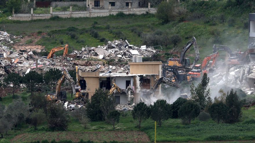 Excavadoras israelíes demuelen edificios en la aldea libanesa de Mais al-Jabal, vista desde el lado israelí de la frontera.