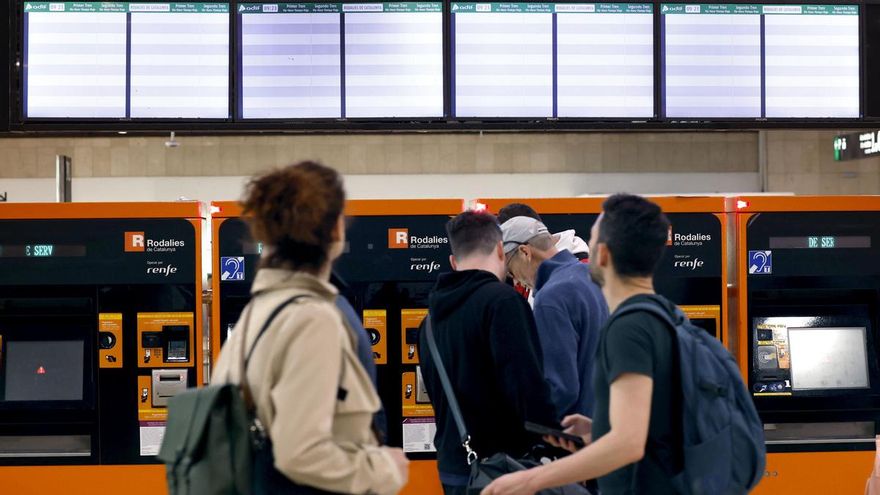 Varias personas ante las taquillas y los paneles informativos de Rodalies que aparecen en blanco en la Estación de Sants