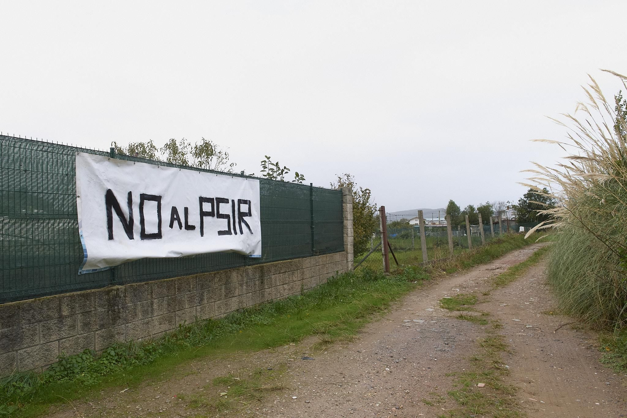 Camino rural con una pancarta contra el PSIR de Laredo.