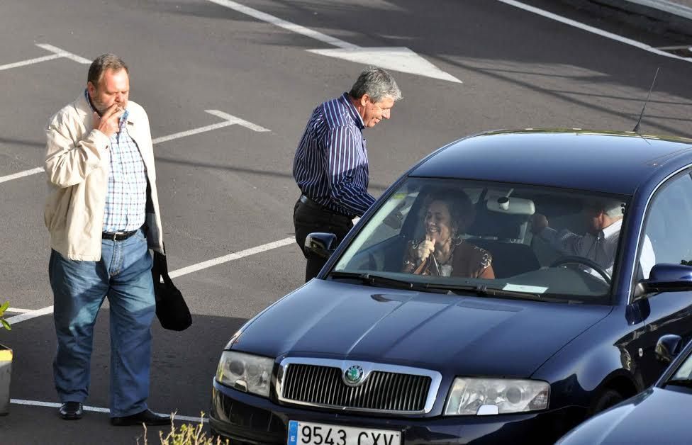 Fernando Bañolas, Mari Mar Julios y Juan Francisco Padrón, ante el coche ofical del Ayuntamiento de La Laguna en el aparcamiento del aeropuerto