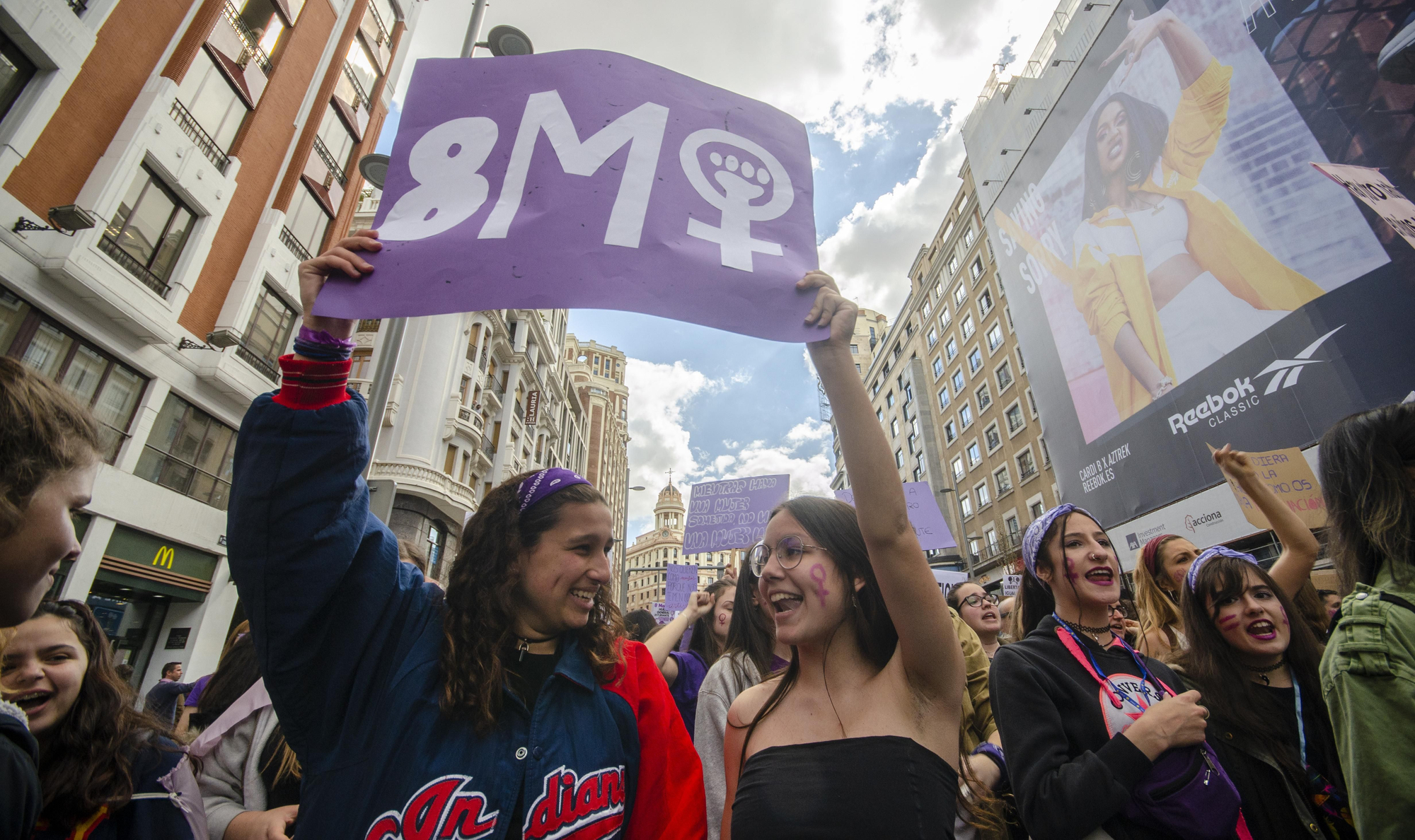 Dos estudiantes sostienen una pancarta durante la manifestación del 8M