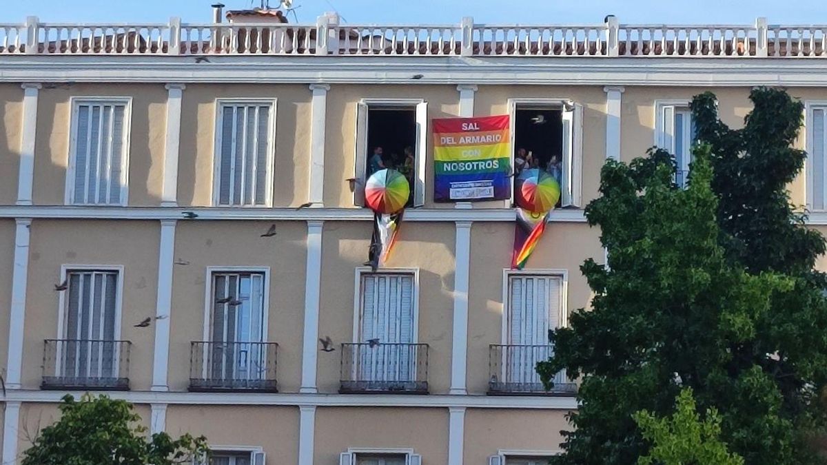 Bandera en balcones de un edificio de la plaza Pedro Zerolo con el mensaje "sal del armario con nosotros".
