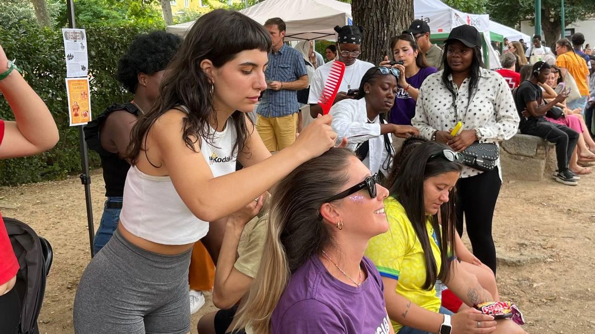 Unas chicas migrantes enseñan cómo trenzar el pelo para crear un peinado característico de su cultura en una jornada de sensibilización en Toledo