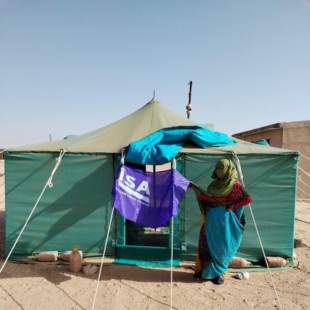 Una mujer en su jaima con la bandera de Izquierda Sindical Asturiana. 