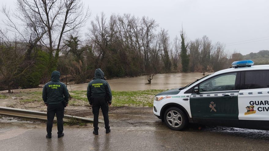 Dos agentes de la Guardia Civil observan una vía afectada por el agua en la provincia de Jaén.