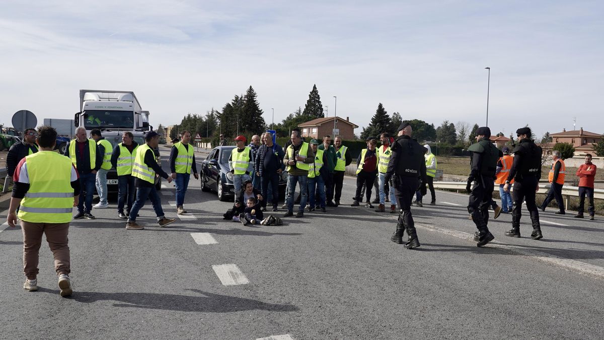 Agricultores y familias cortando la carretera N-120 en Villadangos del Páramo con presencia de la Guardia Civil.