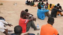 Un grupo de inmigrantes esperan en un centro de internamiento de una ciudad libia, tras ser detenidos cuando se dirigían a la ciudad de Zawara para abordar una embarcación precaria para dirigirse a Europa.