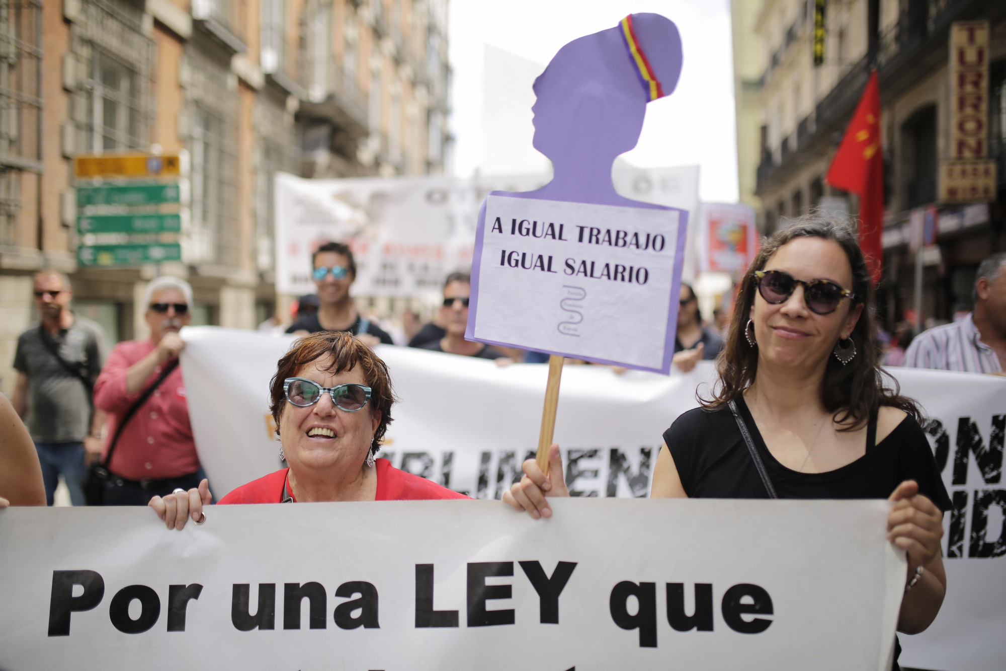 Dos mujeres piden igualdad salarial entre hombres y mujeres en la manifestación del Primero de Mayo.