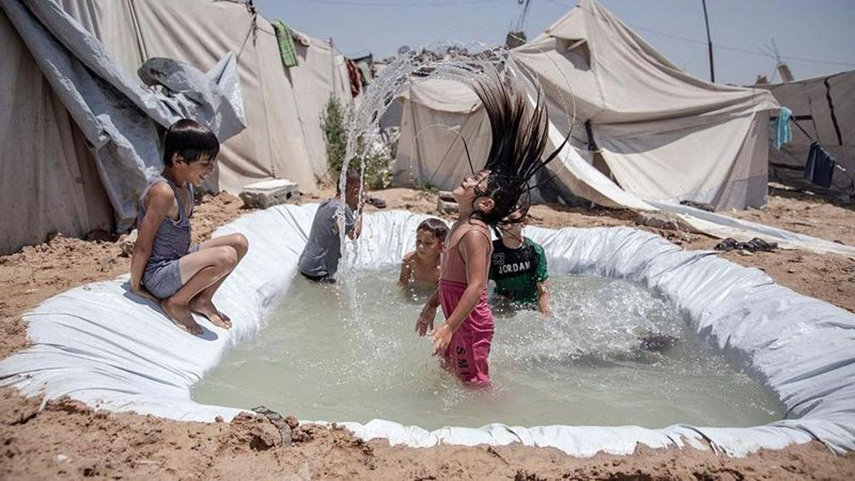 Unos niños juegan en una piscina improvisada en un campamento de desplazados del norte de Gaza, el 16 de julio de 2026.