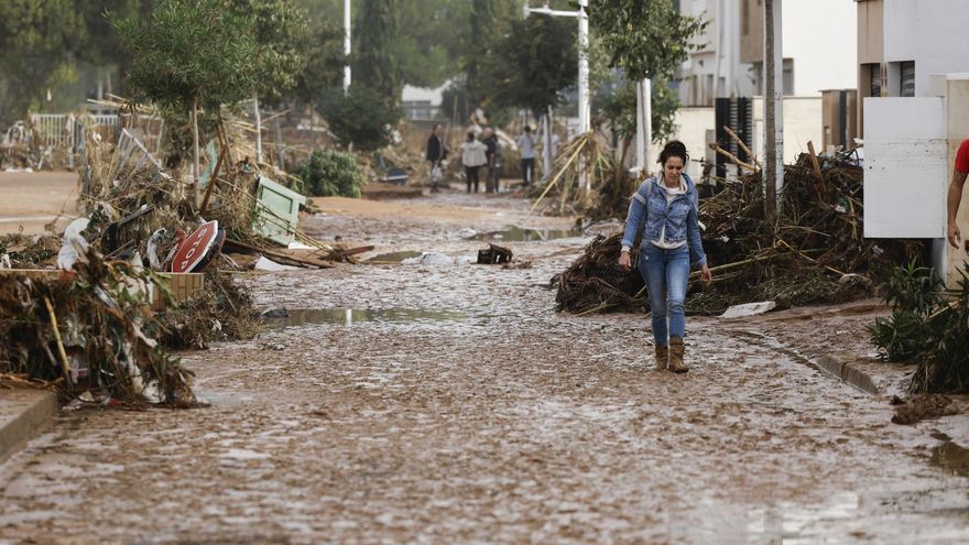 Una mujer camina entre el lodo acumulado por las intensas lluvias de la fuerte DANA este miércoles en Picaña (Valencia).