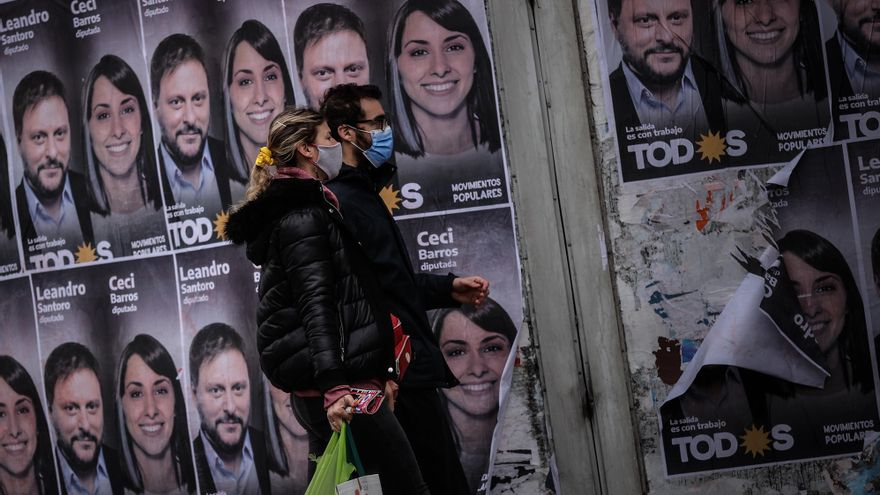 Una pareja camina frente a un cartel con la cara de Leandro Santoro, candidato a Diputado Nacional por el Frente de Todos, el 9 de septiembre de 2021, en la Ciudad de Buenos Aires (Argentina). EFE/ Juan Ignacio Roncoroni