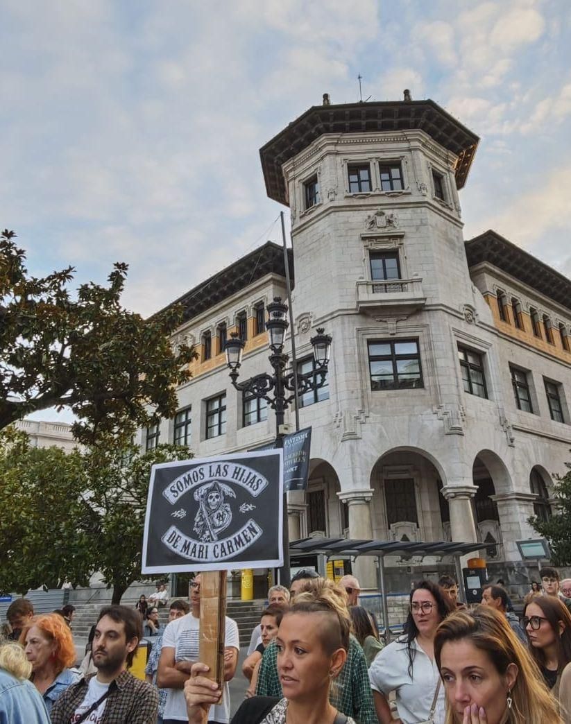 Varias personas congregadas exhibiendo un cartel en apoyo a Maricarmen.