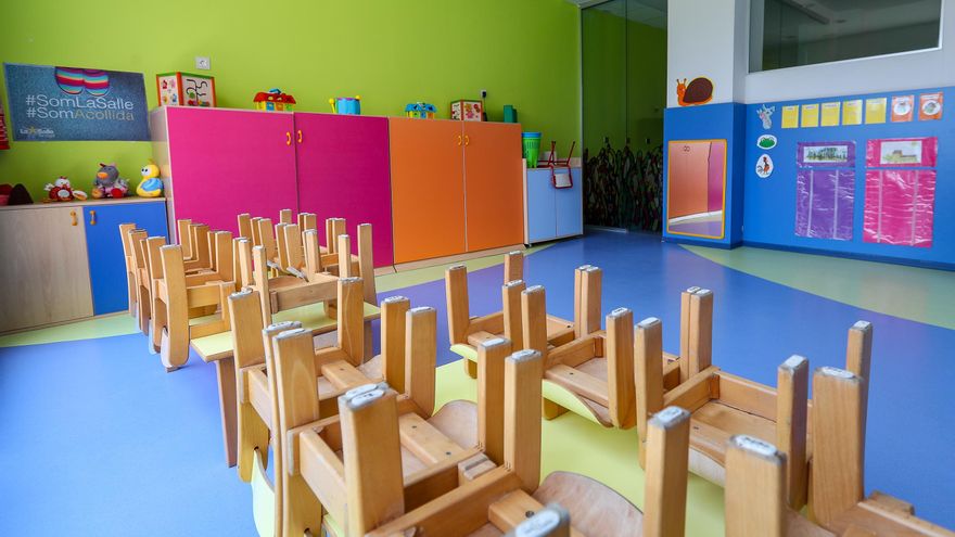 Mesas y sillas recogidas en un aula  de Infantil de un colegio