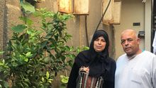 Juma y Atiat junto a la entrada de su casa en la que viven 12 miembros de su familia.