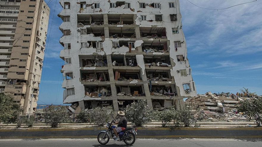 Una persona transita frente a un edificio destruido por los terremotos, este domingo, en Catia La Mar (Venezuela).