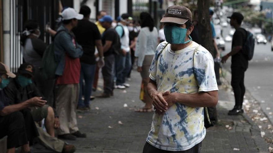Personas con estatus de refugiado y de bajos recursos económicos esperan para recibir víveres y asistencia por parte de la organización "Coalición Nicaragüense en el Exilio", en San José (Costa Rica).