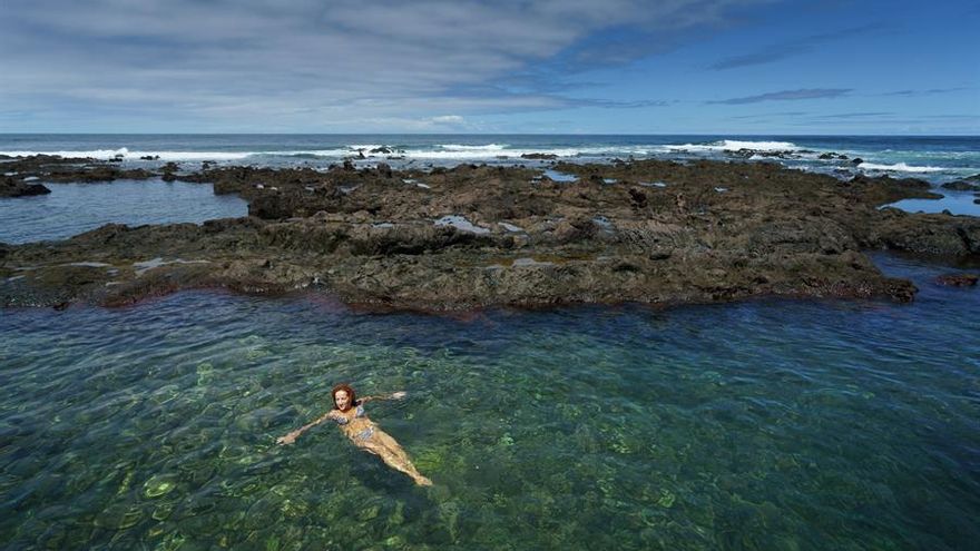 Una mujer se baña en el Charco de La Arena, en Punta del Hidalgo, en el municipio tinerfeño de La Laguna