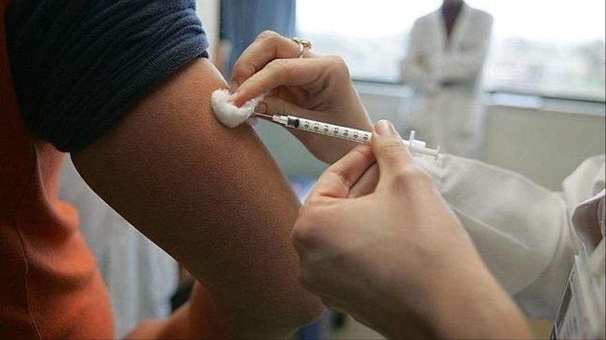Una trabajadora sanitaria administra una vacuna a un paciente.