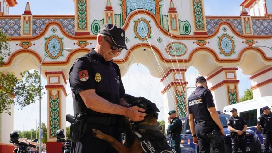 Un agente con un perro adiestrado por la Policía, frente a la portada de la Feria de este año.