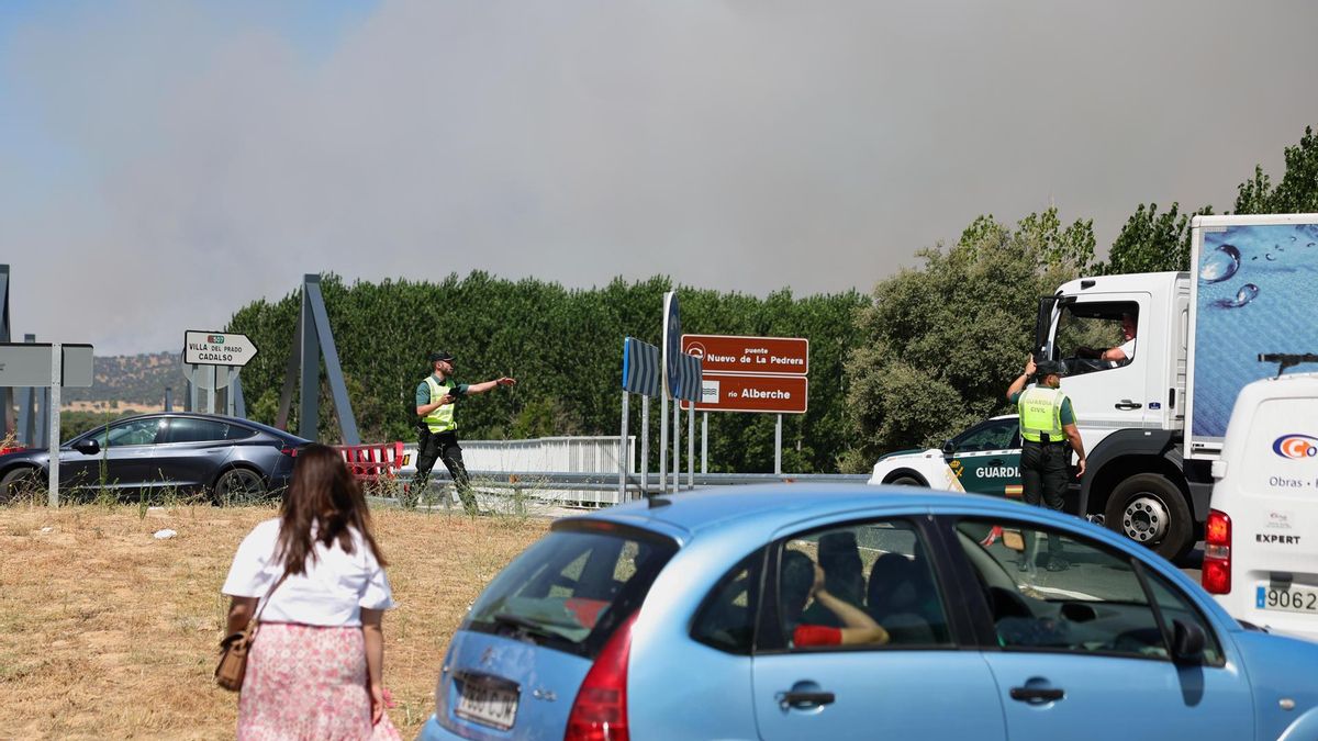 La policía corta el acceso por carretera por el incendio forestal a Villa del Prado, en Madrid.