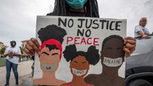 Una manifestante sostiene una pancarta con el lema "Sin justicia, no hay paz" durante una protesta por la muerte de George Floyd en Florida