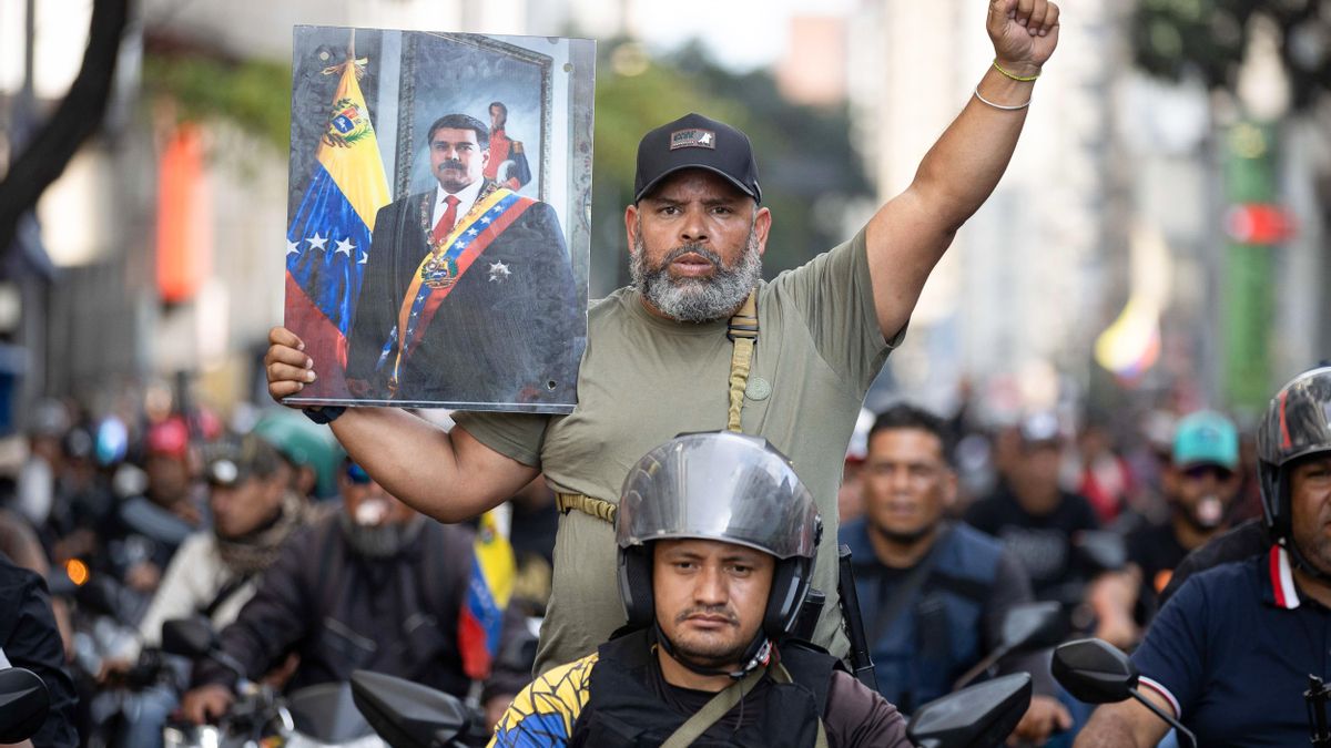 Una persona sostiene un cuadro con la imagen del presidente de Venezuela, Nicolás Maduro, durante una marcha convocada por el chavismo este 4 de enero de 2026, en Caracas (Venezuela). EEFE/ Ronald Peña R