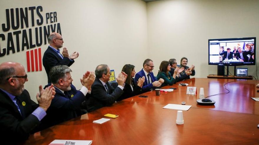 El presidente de la Generalitat de Cataluña Quim Torra (i), la consellera de la Presidencia, Meritxell Budó (2i), el diputado y miembro de la Mesa del Parlament Josep Costa felicitan por videoconferencia, durante una reunión de su grupo parlamentario (JxCat), al ex presidente Carlos Puigdemont y al ex conseller Toni Comín .