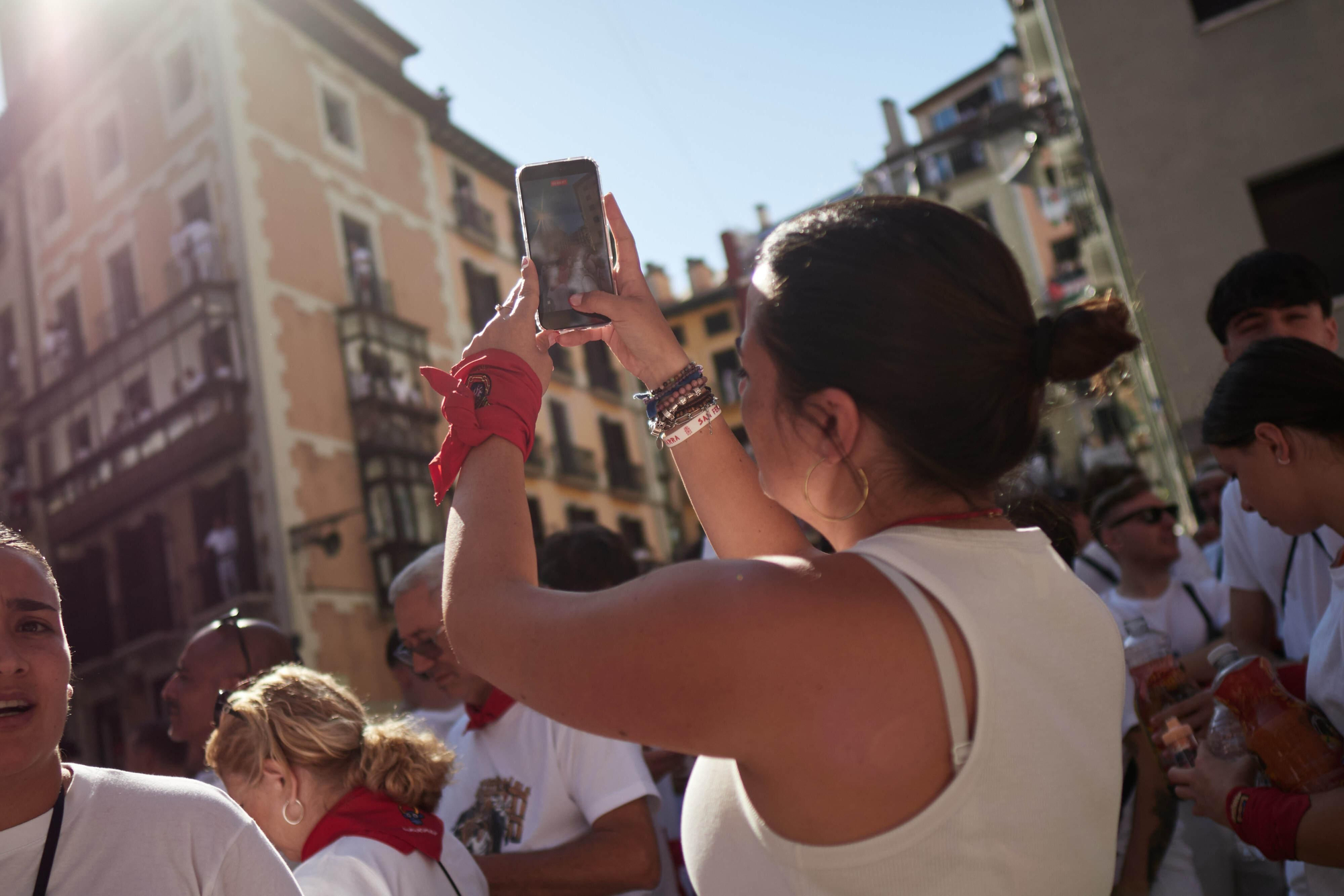Joven fotografiando el ambiente en la plaza del Ayuntamiento momentos previos al chupinazo