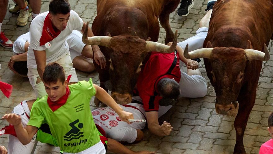 Varios mozos son arrollados por varios toros de la ganadería Miura durante el octavo y último encierro de los Sanferminesste jueves en Pamplona. EFE/J. P. Urdiroz