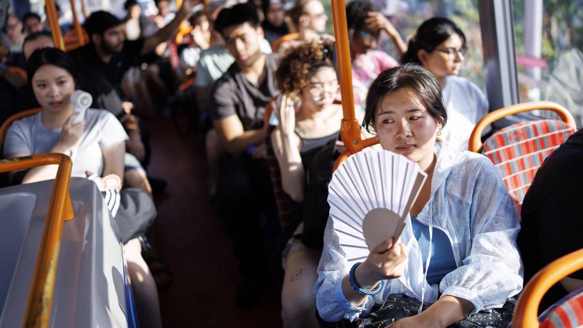 Una persona usa un ventilador para refrescarse en un autobús de Londres.