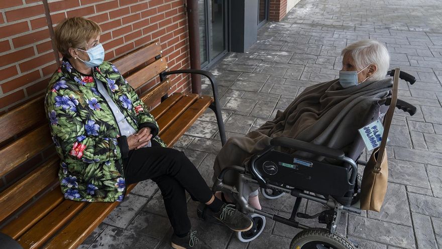 Una familiar y una residente charlan en el exterior de la residencia Virgen de Valencia.