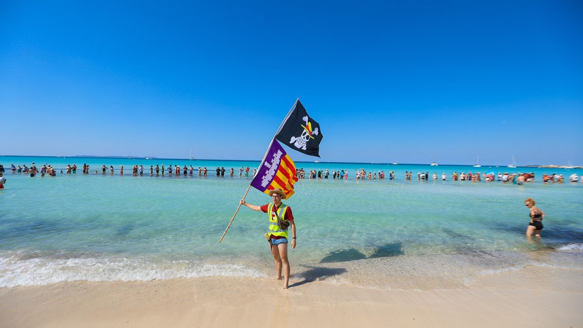 Un representante de la entidad 'Menys turisme, més vida' lleva una bandera del anime One Piece, símbolo de la revolución, y de las Illes Balears.