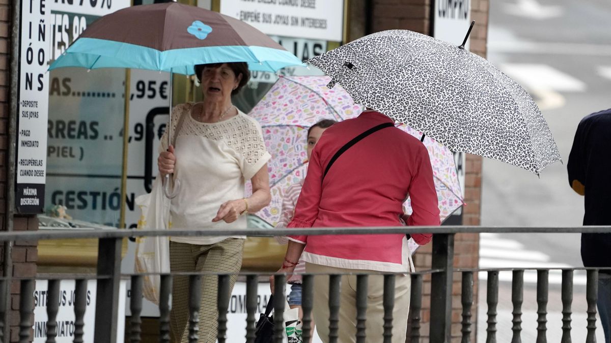 Tres personas se protegen con paraguas de la lluvia  EFE/Paco Paredes