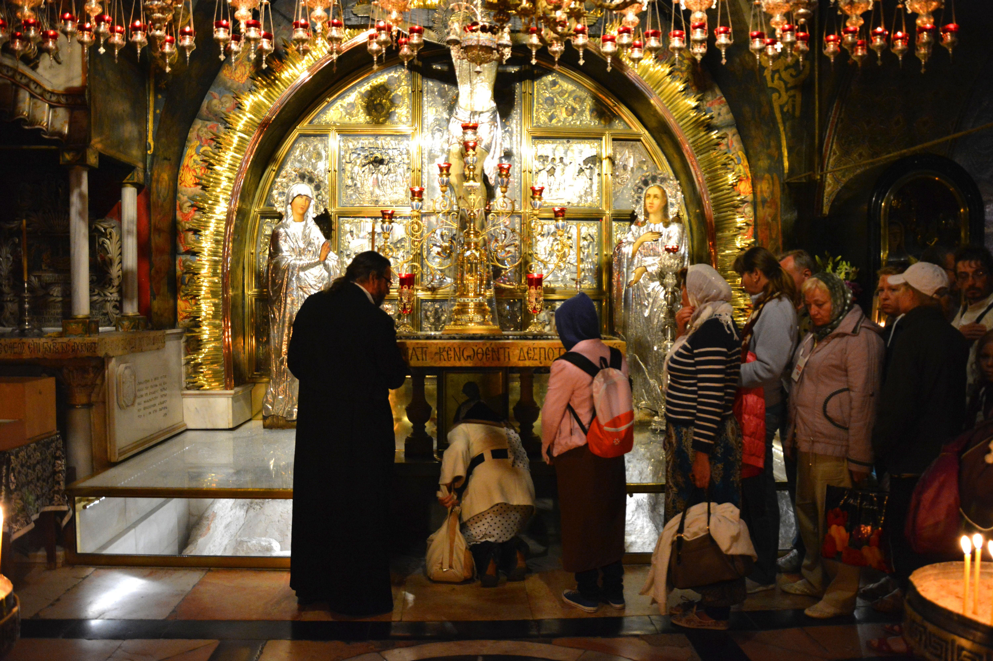Los visitantes de la Basílica del Santo Sepulcro hacen cola para arrodillarse y besar la piedra donde se cree que estaba clavada la cruz de Cristo. Jerusalén / SNM