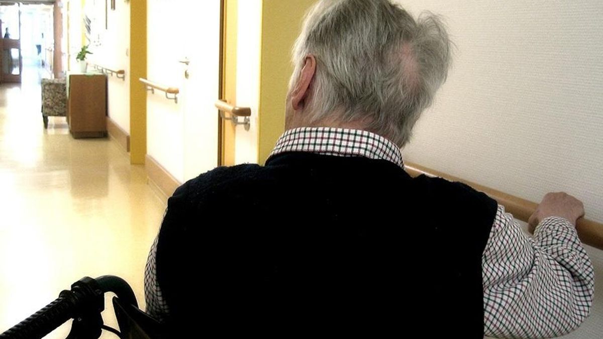 Archivo - Una persona en silla de ruedas se desplaza por los pasillos de una residencia de mayores.
