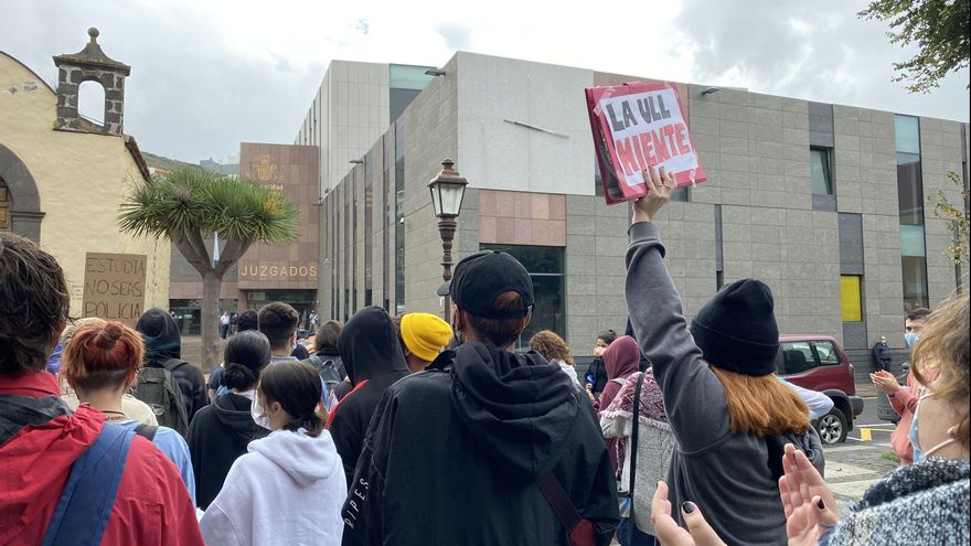 Una persona sostiene un cartel contra la ULL frente a los Juzgados de La Laguna