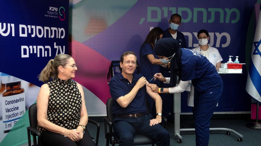 El presidente israeli Isaac Herzog (c) y su mujer tras recibir la tercera dosis de la vacuna anti covid-19 en un centro médico de Ramat Gan, Israel. 