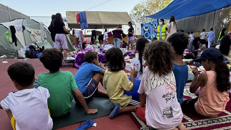 Decenas de madres, jóvenes y niñas que han decidido establecerse, de manera temporal para sentirse más seguras, en el espacio habilitado por la Asociación de Vecinos de Sidi Embarel, un campo de fútbol al aire libre en la barriada de La Reina, en la periferia de Ceuta. Se tumban en el suelo para descansar, sobre mantas que han cedido los vecinos o alfombras que una mezquita les ha dejado. Hay mucha precariedad: no disponen de duchas, solo tienen un baño y la mayor parte del recinto no cuenta con sombra a pesar del fuerte sol en las horas centrales del día. A pesar de las carencias, para Wiam que tiene de 23 años y llegó a la ciudad nadando,, compartir espacio de forma exclusiva con otras mujeres y niños ha sido determinante para superar el impacto emocional de la travesía."Mi padre quería abusar de mí en Marruecos y me amenazó con matarme si volvía. Necesitaba huir de él y cambiar mi vida", relata a EFE sobre la pesadilla de la que logró escapar. EFE/Laura Rincón