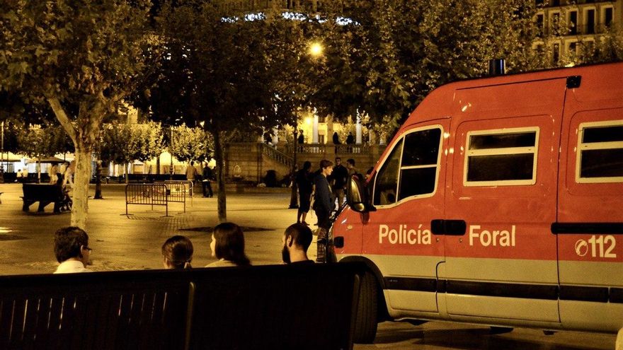 Jóvenes y patrulla de la Policía Foral en una céntrica y prácticamente vacía Plaza del Castillo