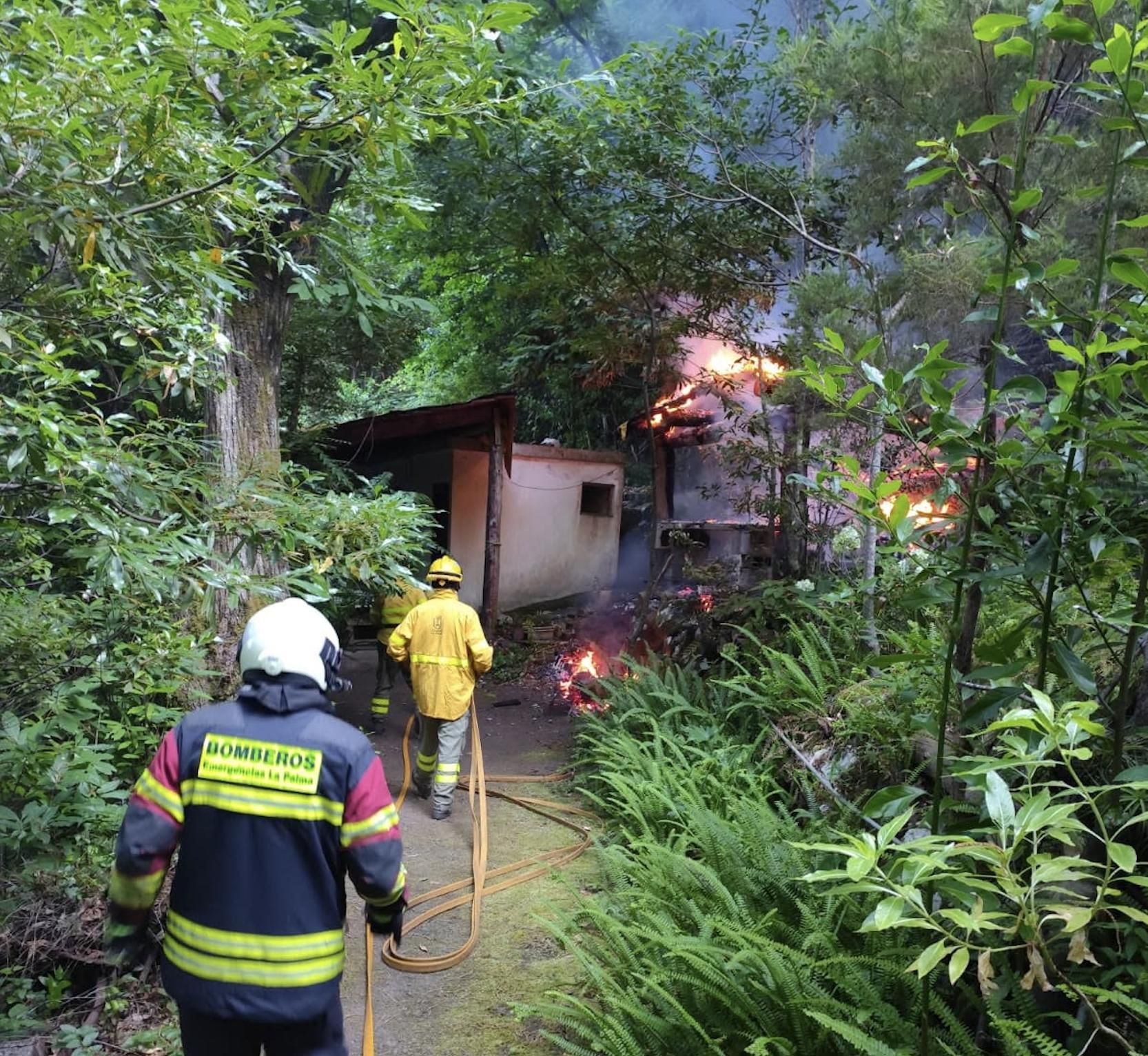 Miembros del dispositivo contraincendios en las tareas de extinción del fuego en una vivienda en la zona de Los Tilos en la tarde del lunes.