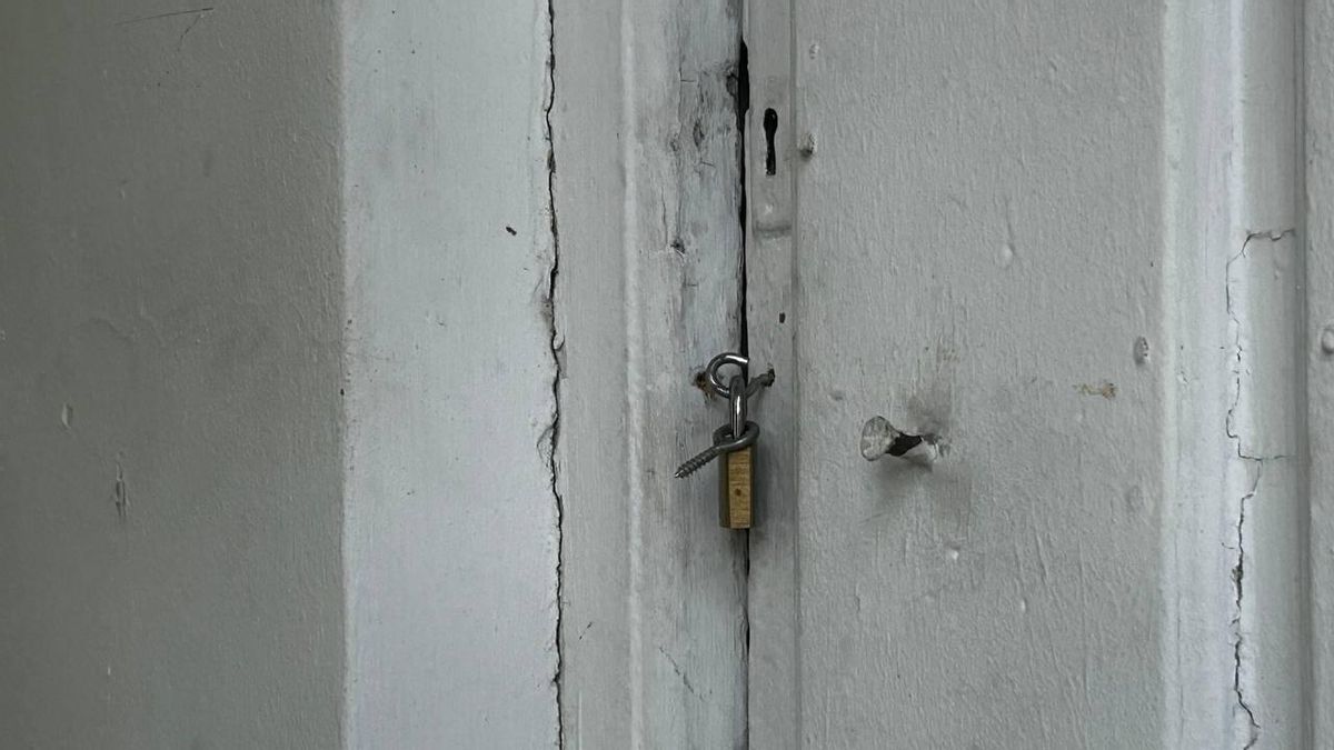Una de las puertas del edificio, cerrada con candado