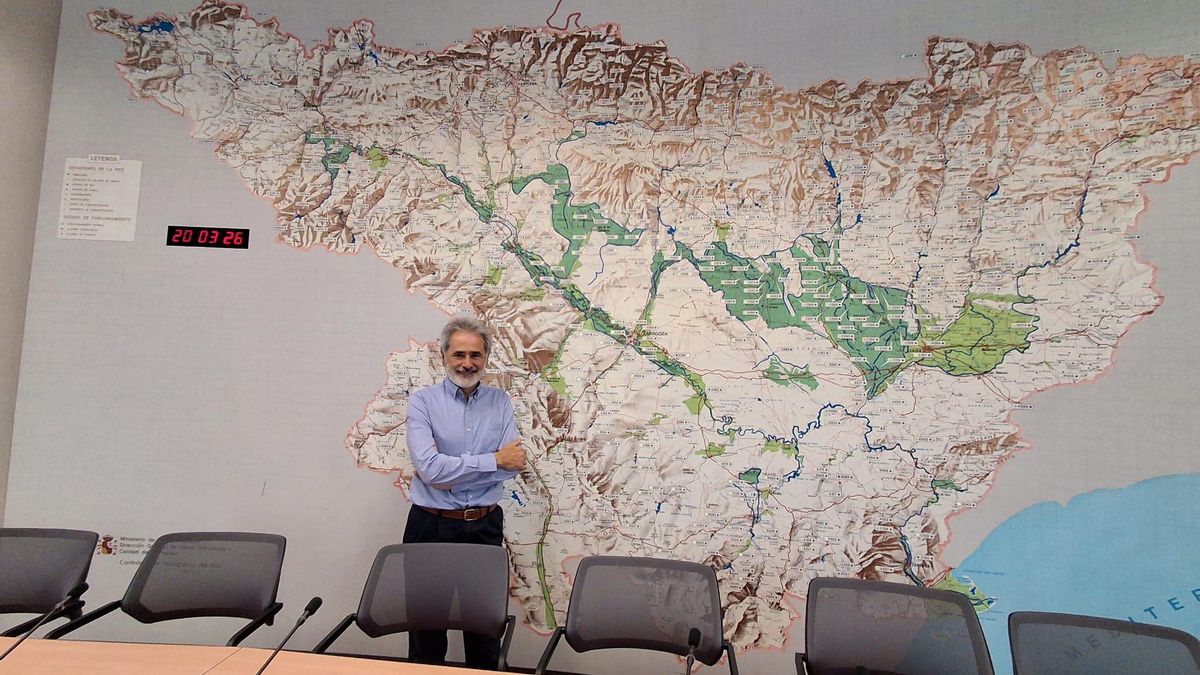 Javier San Román, comisario centenario CHE, en la sala de reuniones con el mapa de la cuenca