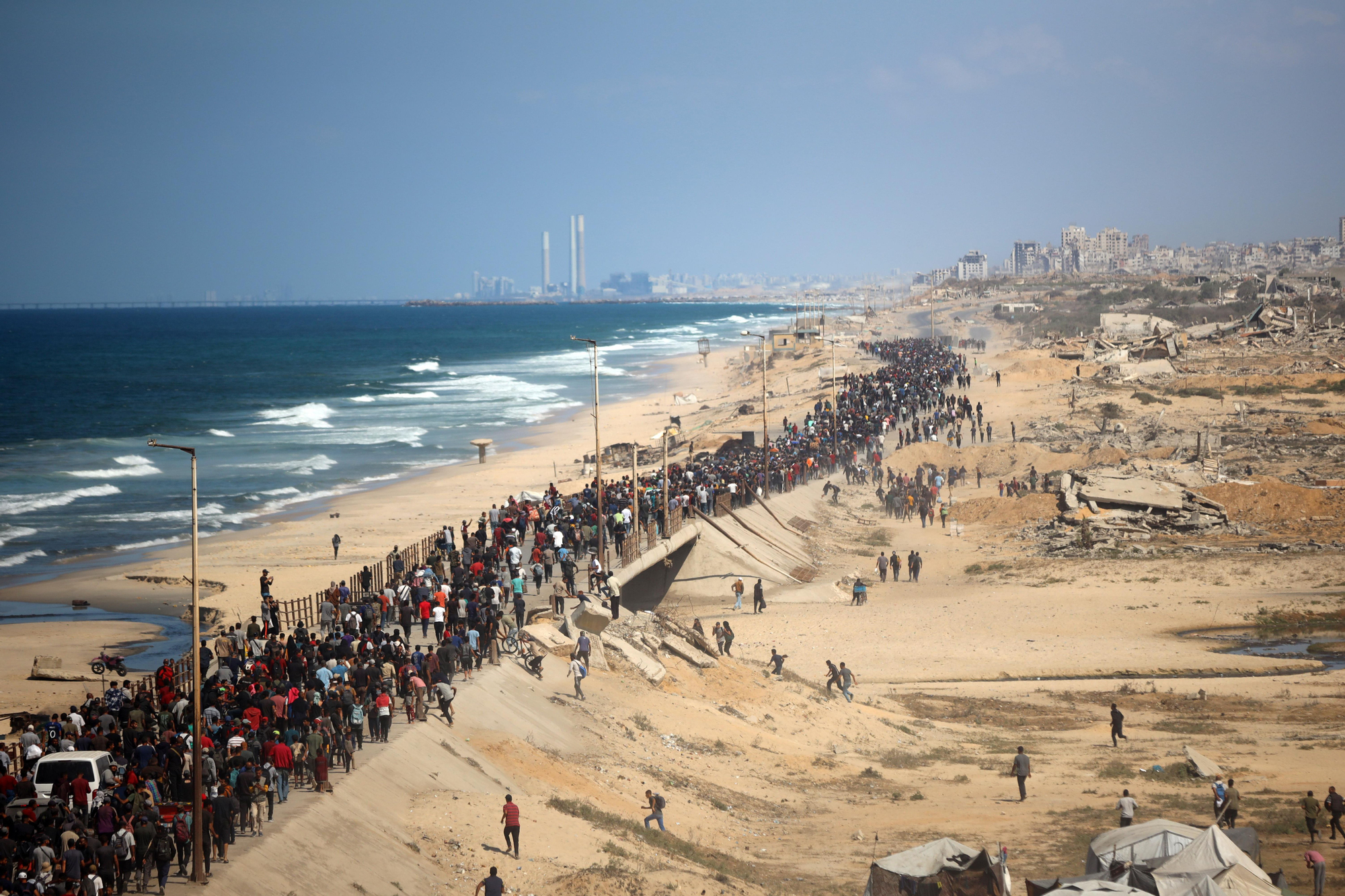 Miles de palestinos caminan por la calle al-Rashid, llevando sus pertenencias mientras se dirigen hacia el norte tras el anuncio de un alto el fuego en la ciudad de Gaza, Gaza, el 10 de octubre de 2025.