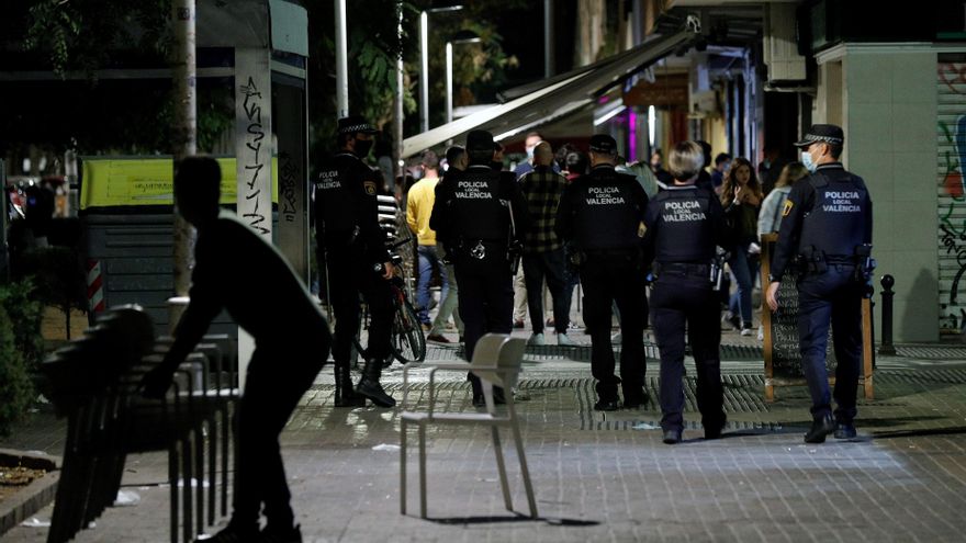 Agentes de la Policía Local de Valencia recorren las terrazas de una conocida zona de ocio de la ciudad vigilando que se cumplen los horarios de cierre y las medidas ante la Covid-19 a poco minutos de la entrada en vigor del toque de queda. EFE/Manuel Bruque