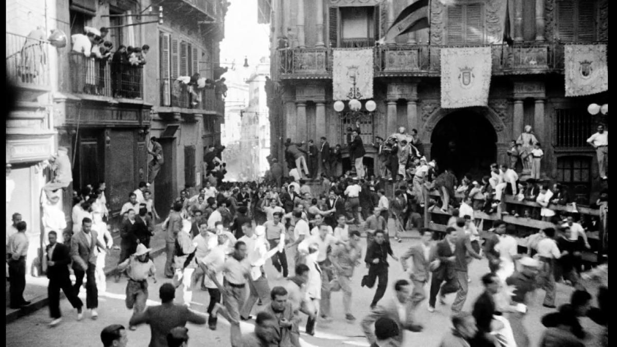 Imagen de uno de los encierros de los Sanfermines de 1936 con la bandera republicana ondeando de la fachada del Ayuntamiento de Pamplona.