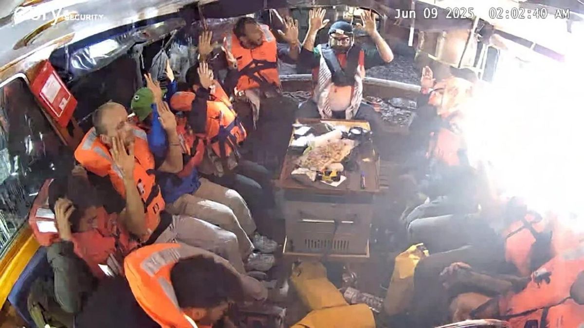 Los tripulantes del barco Madleen con chalecos salvavidas y las manos en alto, el 9 de junio de 2025.