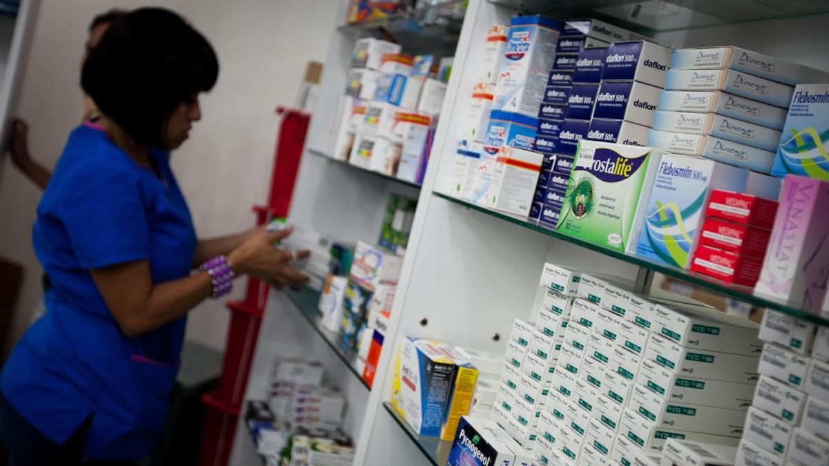 Una trabajadora de una farmacia acomoda los estantes de medicinas. EFE/MIGUEL GUTIERREZEFE/